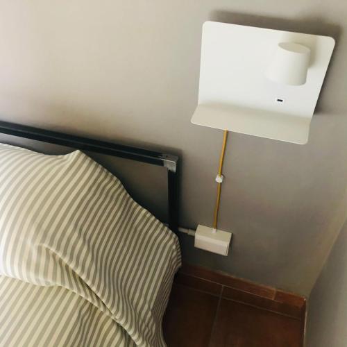a light on the wall next to a bed at Casa Conte Rosso in Avigliana