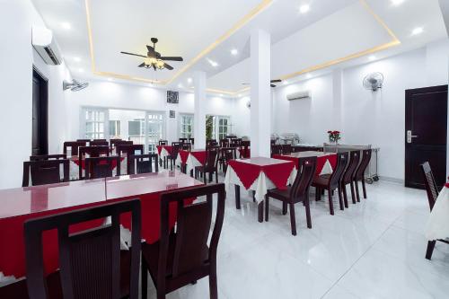 een eetkamer met rode tafels en stoelen bij Gold Coast Hotel Da Nang Hotel in Da Nang