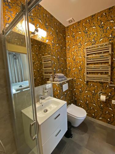 a bathroom with a sink and a toilet in it at Willa Witkacy in Słupsk