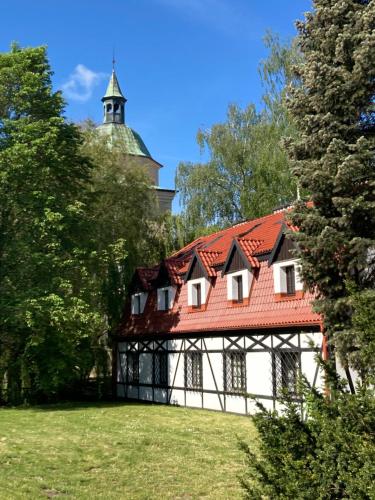 a building with a red roof and a tower at Willa Witkacy in Słupsk