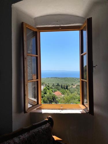 Shotgun Hostel في Vuno: نافذة في غرفة مطلة على المحيط