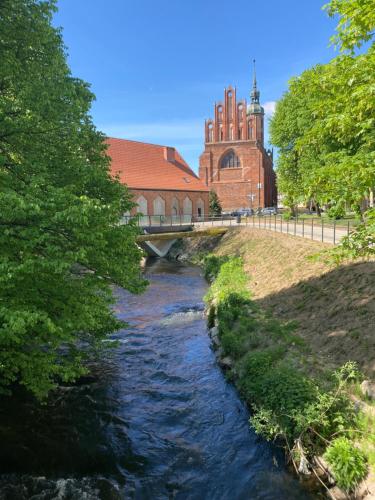 a bridge over a river in front of a building at Willa Witkacy in Słupsk