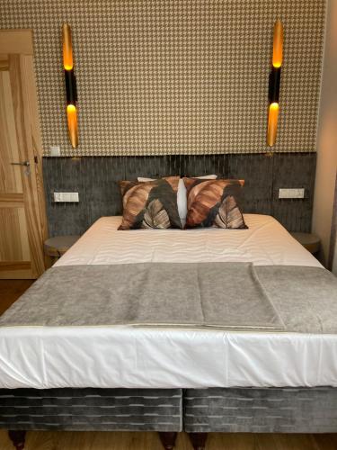 a bedroom with a bed with two lights above it at Willa Witkacy in Słupsk