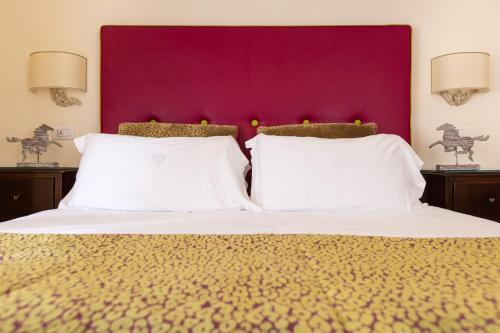 a bedroom with a large bed with a purple headboard at Palazzo Marziale in Sorrento