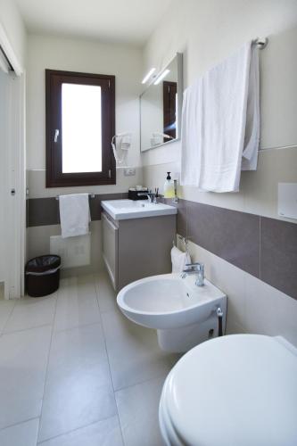 a bathroom with a white toilet and a sink at Xenia Hotel in Villasimius