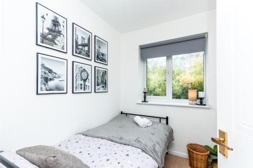 a bedroom with black and white pictures on the wall at Cosy Contractor House & Garden & Free Parking in Swindon