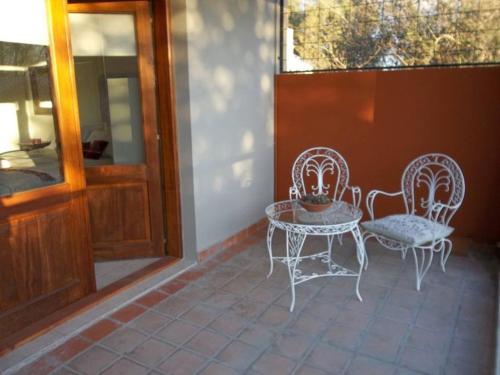 a patio with two chairs and a table and a window at Hosteria Casa de Paula in Trelew