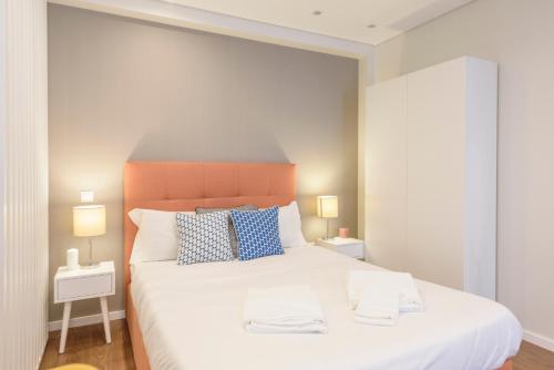 a bedroom with a large white bed with two lamps at Terro Collection - Eça de Queirós in Braga