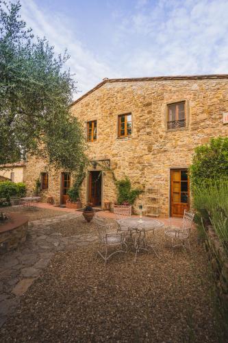 a stone building with a table and chairs in front of it at Il Casello Country House in Greve in Chianti