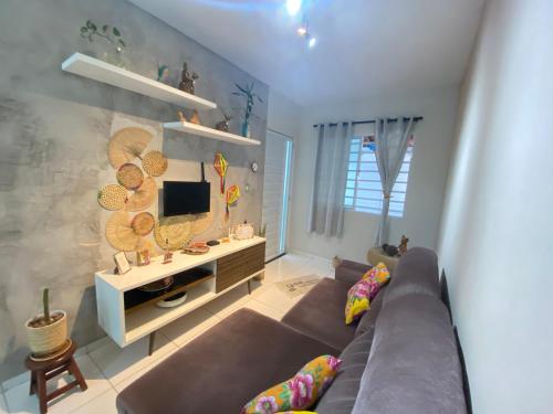 a living room with a couch and a tv at Casa 181 Alto do Moura in Caruaru