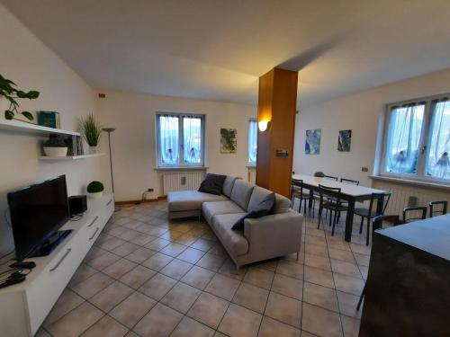 uma sala de estar com um sofá e uma televisão em Appartamento nel verde circondato dalle montagne em Vo Sinistro