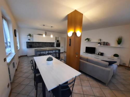 a kitchen and living room with a table and a couch at Appartamento nel verde circondato dalle montagne in Vo Sinistro