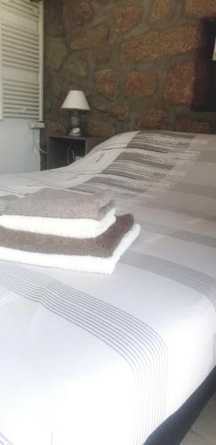 Una cama blanca con toallas encima. en Chez Robert et Sylvie en Pianottoli-Caldarello