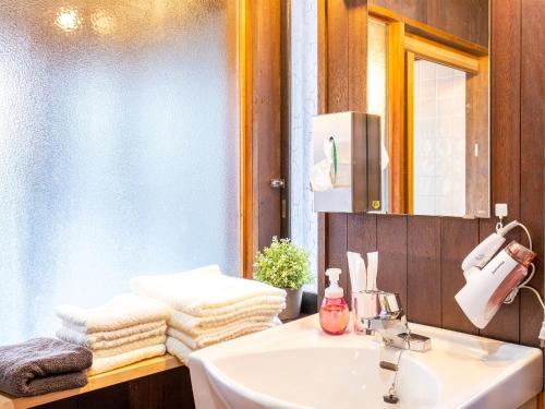 a bathroom with a sink and a mirror and towels at Izu Ricca in Izunokuni