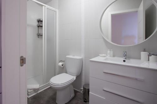 a white bathroom with a toilet and a sink at La Meruxa, adosado a 2 km de la playa VV-2244-AS in Llanes