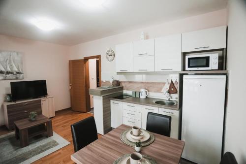 a kitchen with a table and a dining room at Apartmani Zračak in Zlatibor
