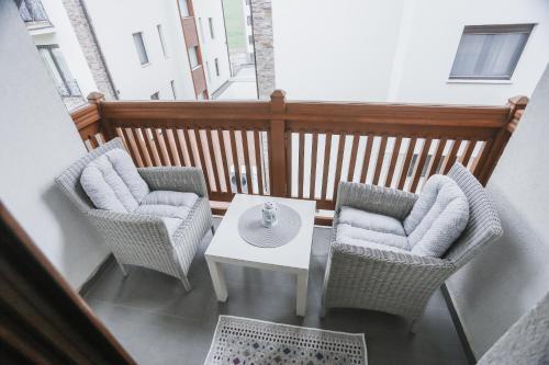 a balcony with two chairs and a white table at Apartmani Zračak in Zlatibor