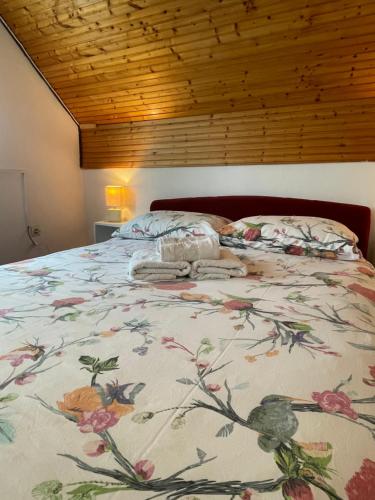 - une chambre dotée d'un lit avec un couvre-lit floral dans l'établissement Apartment Plavo oko, à Smoljanac