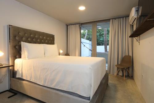 1 dormitorio con 1 cama blanca grande y balcón en Viento Beach Lodge, en Dorado