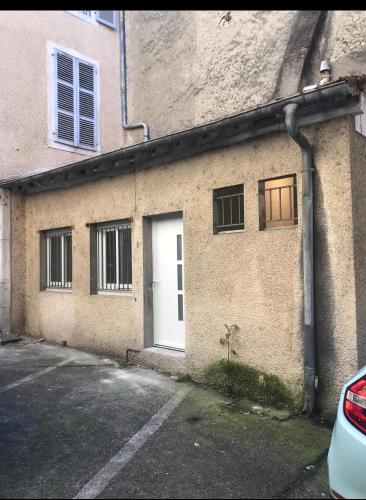 - un bâtiment en briques avec une porte et des fenêtres blanches dans l'établissement Cosy Yucca - 1CH - Quartier des Halles & Parking, à Pau