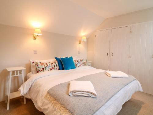 a bedroom with a large bed with towels on it at Fox Hat Cottage in Newton Abbot