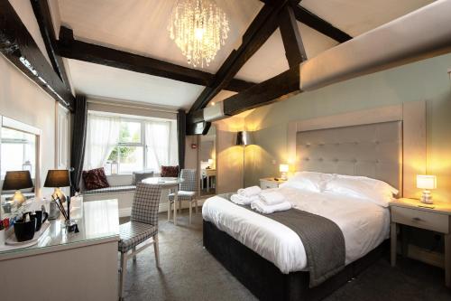 a bedroom with a large bed and a desk and a room at Maypole Inn in Settle