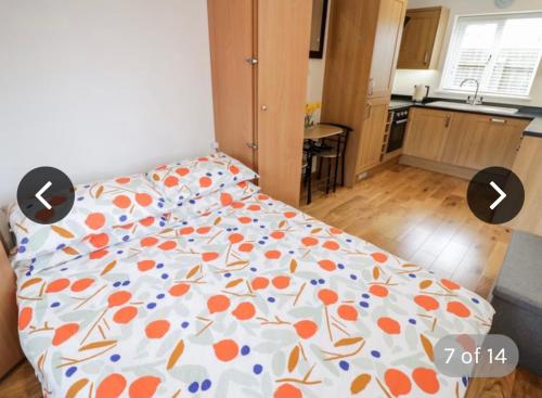 a bedroom with a bed with an orange and blue comforter at The Lodge in Eckington