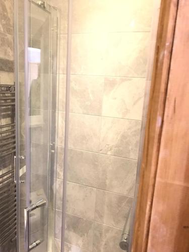 a shower with a glass door in a bathroom at Holywell Grange Farm in Whitley Bay