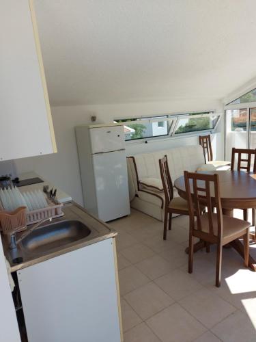 a kitchen with a sink and a table and chairs at Villa Lyudmila in Utjeha