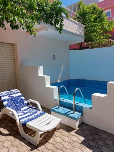 a pool with a bench and stairs next to a house at Villa Lyudmila in Utjeha