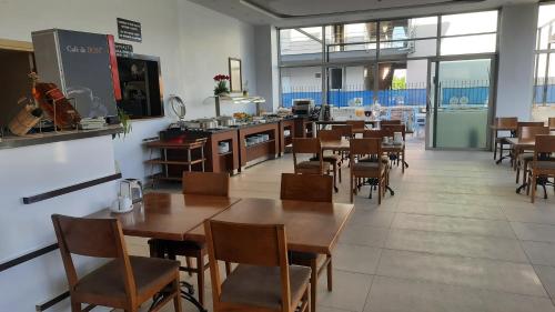a restaurant with wooden tables and chairs and a kitchen at Pamukkale Batu Termal in Pamukkale