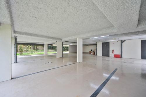 une pièce vide avec un sol en béton et des plafonds blancs dans l'établissement Blue Nights Appartements 69, à Chennevières-sur-Marne