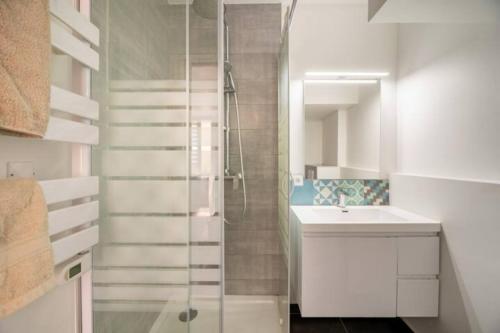 une salle de bain blanche avec une douche et un lavabo dans l'établissement Appartements Marseille cours Julien, à Marseille