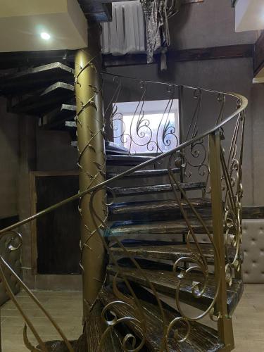 a spiral staircase in a room with a column at AL BARAKA in Borovoye