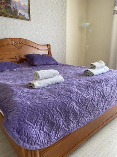 a purple bed with towels on top of it at AL BARAKA in Borovoye