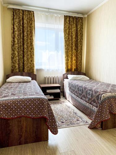 a bedroom with two beds and a window at AL BARAKA in Borovoye
