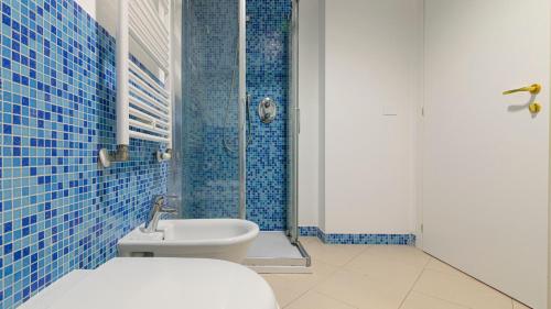 a blue tiled bathroom with a toilet and a shower at Residenza Excelsior in Vasto
