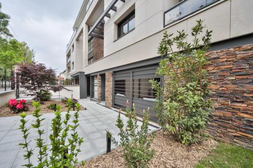 um edifício de tijolos com um pátio com plantas em Blue Nights Appartements 71 em Chennevières-sur-Marne