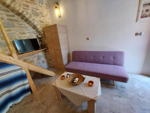 a living room with a purple couch and a table at Ήλιος Πατσακης in Symi