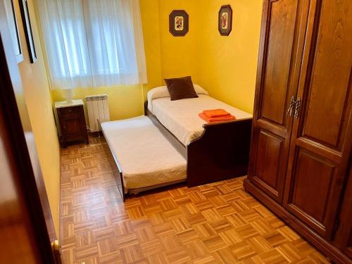 a small bedroom with a bed and a window at Apartamento en A Pontenova in A Pontenova