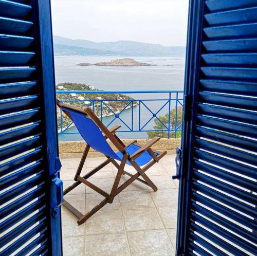 a blue chair sitting on a balcony overlooking the ocean at Villa Iokasti (sea view) in Pefkali