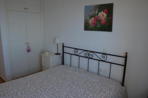 a bedroom with a bed and a painting on the wall at Villa Iokasti (sea view) in Pefkali