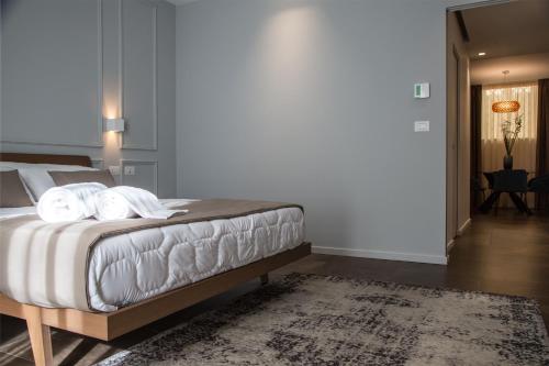 a bedroom with a bed with white sheets and a rug at Plebis - B&B in Sicilia nel centro storico di Catania in Catania