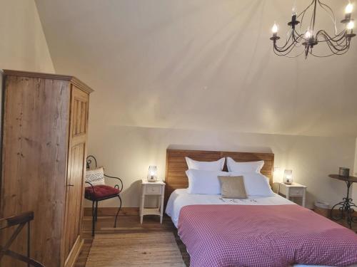Schlafzimmer mit einem Bett und einem Kronleuchter in der Unterkunft Ferme de l'Abbaye in Dury