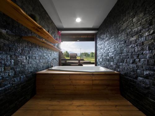 a bathroom with a bath tub in a brick wall at TatryView Apartments by KingDubaj in Veľká Lomnica