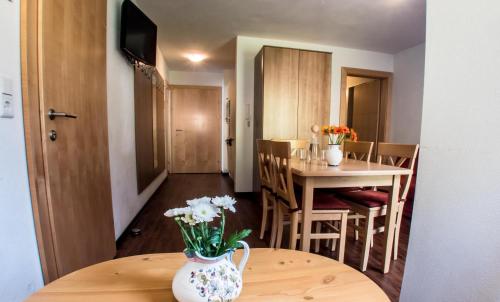 a room with a table and a vase of flowers on a table at Alpenapart Saphir in Sölden
