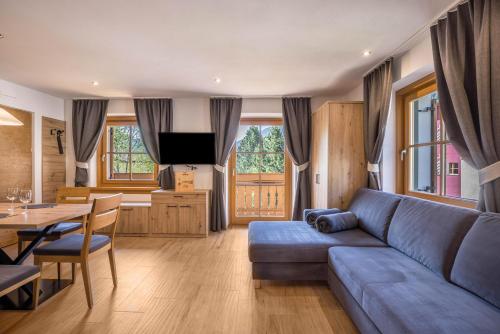 Una sala de estar con un sofá azul y una mesa. en Lechnerhof Fane Alm, en Valles