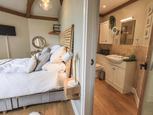 ein Schlafzimmer mit einem Bett und einem Waschbecken in der Unterkunft Oversands Cottage in Grange Over Sands