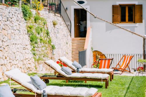 a group of lounge chairs sitting on the grass at Villa Le Murelle in Tramonti