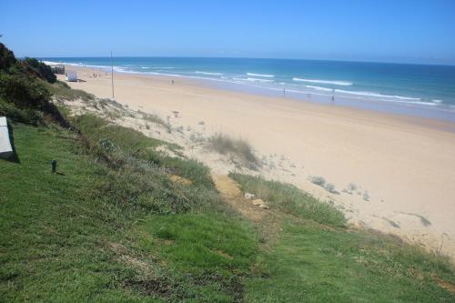 a beach with people walking on the sand and the ocean at Vivir en la playa in Roche